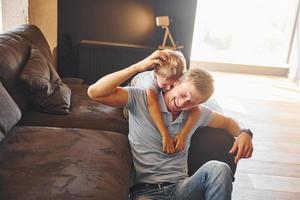 jouer et s'amuser. père et fils sont à l'intérieur à la maison ensemble photo