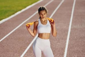 debout et regardant la caméra. jeune femme en vêtements sportifs fait de l'exercice à l'extérieur photo