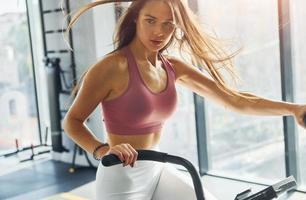 exercices d'endurance. belle jeune femme avec un type de corps mince est dans la salle de gym photo