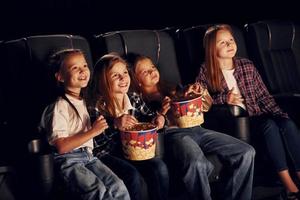 se détendre et s'amuser. groupe d'enfants assis au cinéma et regardant un film ensemble photo