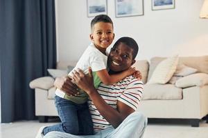 famille heureuse. père afro-américain avec son jeune fils à la maison photo