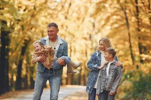 quatre personnes. famille heureuse est dans le parc à l'automne ensemble photo