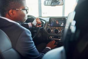vue arrière. jeune homme d'affaires afro-américain en costume noir est dans l'automobile photo