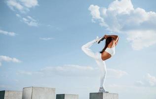sur le cube de ciment. photo d'une femme sportive faisant des exercices de fitness près du lac pendant la journée
