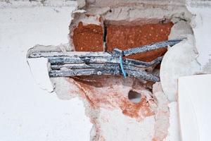 vieux câbles électriques dans un mur de briques. câblage dangereux photo