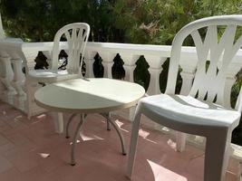 panorama d'un élégant balcon décoré avec mobilier d'extérieur en rotin, oreillers lumineux et plantes photo