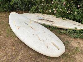 deux planches de surf blanches reposent sur le sol dans le pays tropical paradisiaque de l'est de la station. photo