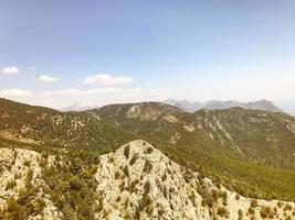 montagnes dans un pays chaud et tropical contre un ciel bleu. des plantes vertes, des arbres et des buissons poussent sur les montagnes. vue à vol d'oiseau photo