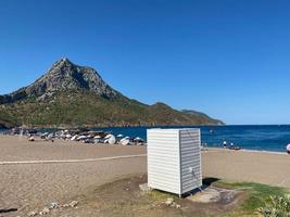 ne dressing ou cabine blanc-bleu sur une plage de sable vide à pirita par une journée d'été venteuse. beau ciel bleu avec des nuages photo