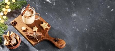 bannière avec lait de poule de noël, biscuits en forme de coeur et branches de sapin avec lumières bokeh sur gris. photo