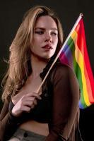 femme lesbienne tenant le drapeau arc-en-ciel isolé sur fond noir. symbole international lgbt de la communauté lesbienne, gay, bisexuelle et transgenre. photo