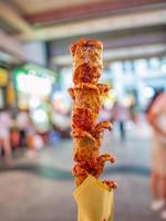 gros plan sur des saucisses frites chinoises sur un stand de nourriture de rue chinoise dans une rue piétonne photo