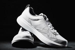 paire de baskets blanches sur fond noir photo