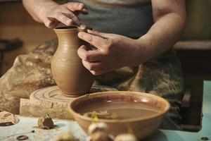 processus de fabrication d'un pot en argile sur un tour de potier en atelier. potier au travail photo