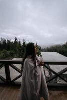 femme buvant du thé sur le balcon confortable d'une maison de campagne. photo