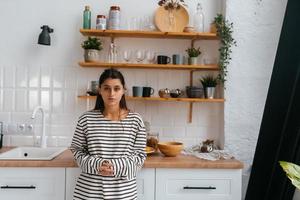 jeune femme debout près du bureau dans la cuisine photo