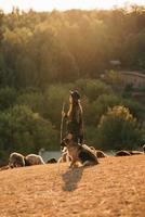 Berger femelle avec un chien broute un troupeau sur la pelouse photo