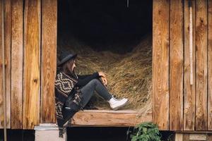 jeune femme brune assise à la grange. style campagnard. photo