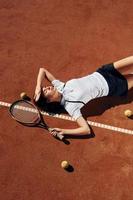 allongé sur le sol. La joueuse de tennis est sur le terrain pendant la journée photo