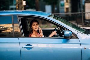 femme assise dans la voiture et utilisant son smartphone. photo