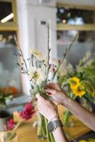 femme fleuriste fait un bouquet de fleurs sauvages fraîches photo