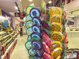 groupe de sucettes de sucre aux couleurs vives exposées à la vente dans un magasin de bonbons dans des emballages en plastique individuels, mise au point sélective. photo