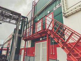 construction d'un nouveau complexe à l'usine. structures métalliques de couleur rouge pour le levage vers la salle de service. à côté du tuyau métallique photo