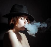 portrait d'une jeune fille dans la fumée de cigarettes photo