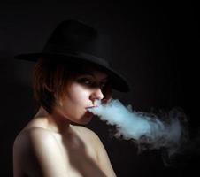 portrait d'une jeune fille dans la fumée de cigarettes photo
