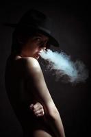 portrait d'une jeune fille dans la fumée de cigarettes photo