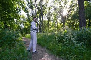 un jeune homme en costume de sport gris se tient debout avec une bouteille de w photo