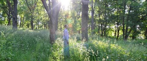 un jeune homme en costume de sport gris se tient en face du soleil parmi photo