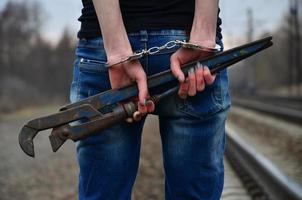 la fille menottée avec la clé à pipe sur la voie ferrée photo