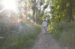 un jeune homme en costume de sport gris court le long du chemin parmi les photo