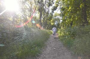 un jeune homme en costume de sport gris court le long du chemin parmi les photo