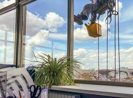 laveur de vitres sur le côté de l'immeuble de bureaux, gros plan. photo