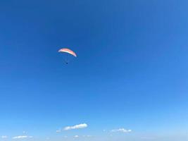 jeune homme parapente pendant l'été au large des falaises de baja, mexique photo