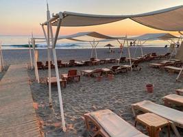 Chaises longues et parasol avec parasols sur la plage sur la mer en vacances dans un pays tropical de l'Est chaud touristique Southern Resort photo