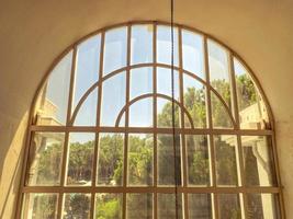 fenêtre au sol dans un hôtel pour touristes. fenêtre en verre avec une grille métallique sur le dessus. verdure, arbres à l'extérieur photo