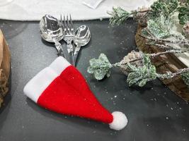 table de noël set fourchette, cuillère et couteau avec cônes de décoration, arcs, branche sur fond neigeux, nouvel an et concept de vacances de noël photo