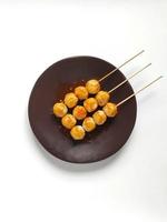 Brochettes de boulettes de viande de poulet épicées sur la plaque brune sur fond blanc photo