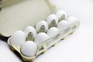 oeufs de poule blancs frais dans un sac en papier. oeufs blancs dans un emballage sur fond blanc. oeufs du magasin. photo