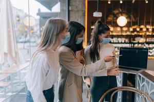 trois femmes d'affaires avec leurs masques faciaux débattant de différents points de vue sur le travail photo