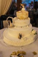gâteau de mariage à trois niveaux sur la table des mariés photo