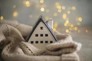 maison en céramique isolée par un pull chaud. concept de protection de la maison et manque de chaleur à la maison en hiver photo