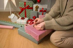 femmes tenant une boîte cadeau avec un ruban rouge sur le sol et des cadeaux d'emballage photo