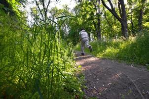 un jeune homme en costume de sport gris court le long du chemin parmi les photo