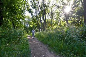 un jeune homme en costume de sport gris court le long du chemin parmi les photo