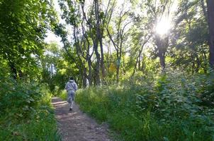 un jeune homme en costume de sport gris court le long du chemin parmi les photo