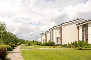 rangée de cottages modernes. toute nouvelle rangée de maisons unifamiliales. conception moderne de résidences de vie urbaine avec cours privées, finitions sophistiquées, nouveau développement. aménagements extérieurs verts, pelouse photo